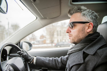 a man driving a car on the road in the city