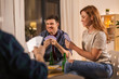 © Syda Productions - friendship, leisure and entertainment concept - happy friends playing cards game and drinking beer at home in evening