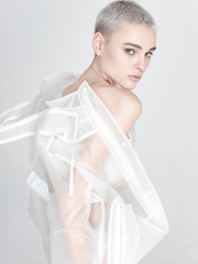 Young model putting on transparent jacket