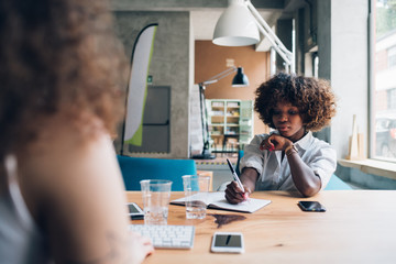 young african businesswoman working in co working office with colleague