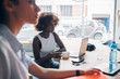 © Eugenio Marongiu - two young multiracial businesswomen sitting in modern co-working office