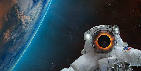 Wall Mural - solar eclipse on the face of astronaut against spectacular blue earth 
