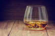 © minicase - glass of whiskey with ice on a wooden background