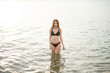© tonefotografia - Beautiful woman in black bikini is enjoying with sea water on the beach