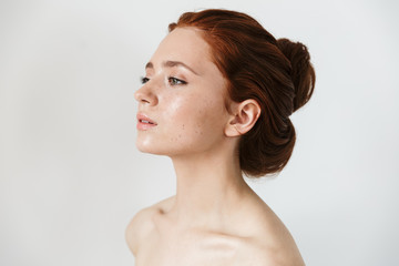 Wall Mural - young redhead woman posing isolated over white wall background.