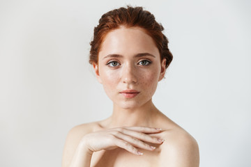 Wall Mural - young redhead woman posing isolated over white wall background.