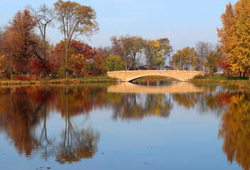 Wall Mural - beautiful fall landscape with a bridge in the city park. colored trees and bridge in sunlight reflec