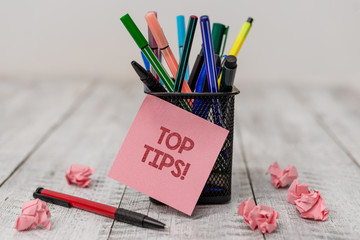 Conceptual hand writing showing Top Tips. Concept meaning small but particularly useful piece of practical advice Writing equipment and paper scrap with blank sheets on wooden desk