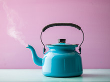 Steaming Kettle With Boiling Water Against Pink Background
