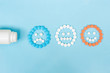 © Olga - Multicolored pills and funny faces and a plastic bottle on a blue background. The concept of antidepressants and healing. Copy space.