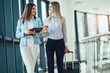© Mediteraneo - Businesswomen hold luggage travel to business trip.