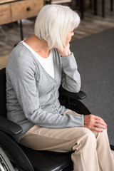 Wall Mural - sad disabled senior woman sitting on wheelchair and looking away