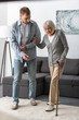 © LIGHTFIELD STUDIOS - full length view of man helping senior mother with cane at home