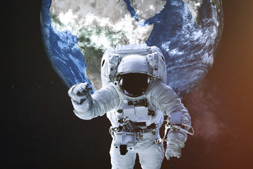 Wall Mural - astronaut in a front of earth planet of solar system with lens flare. science fiction. elements of t