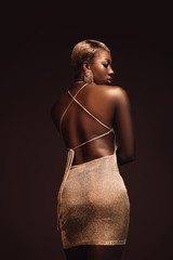 Wall Mural - rear view of fashionable african american woman with short hair isolated on brown