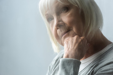 Wall Mural - selective focus of pensive senior woman with grey hair propping face with hand