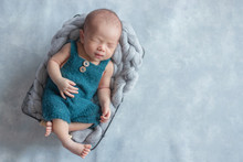 Adorable Newborn Baby Sleeping In Cozy Room. Cute Happy Infant Baby Portrait With Sleepy Face In Bed. Soft Focus At The Baby Eyes. Newborn Nursery Care Concept.