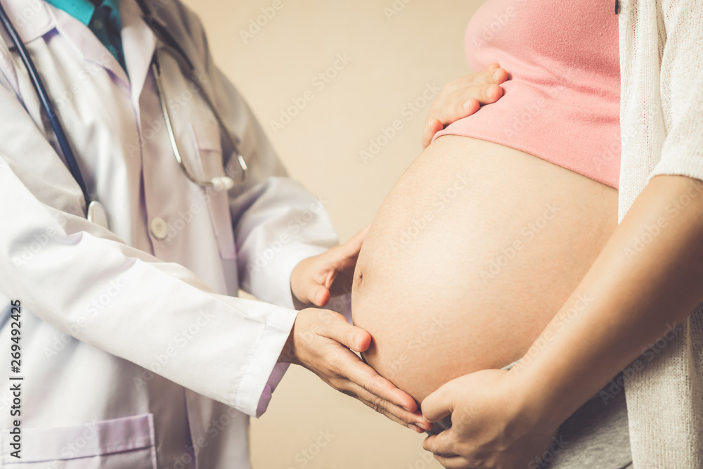Happy pregnant woman visit gynecologist doctor at hospital or medical clinic for pregnancy consultant. Doctor examine pregnant belly for baby and mother healthcare check up. Gynecology concept. - obrazy, fototapety, plakaty 