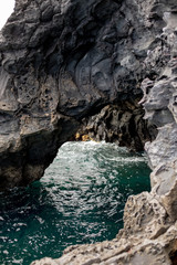 Wall Mural - Rocky arch in the ocean near the beach