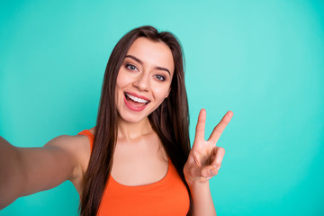 Wall Mural - Close up photo beautiful amazing her she lady coquette make take selfies v-sign symbol hand arm tell speak say skype toothy wear casual orange tank-top isolated bright blue teal turquoise background