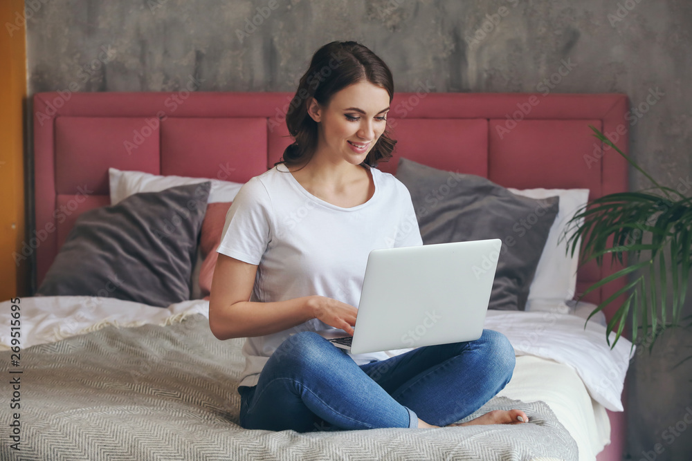 Beautiful young woman with laptop resting at home