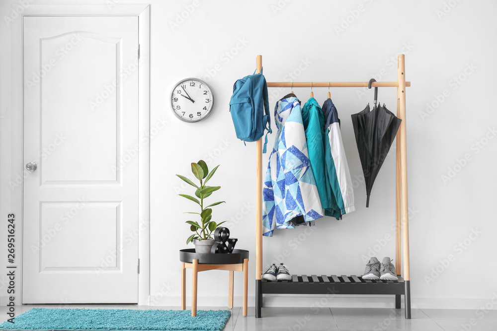 Rack with clothes in stylish interior of hall - obrazy, fototapety, plakaty 