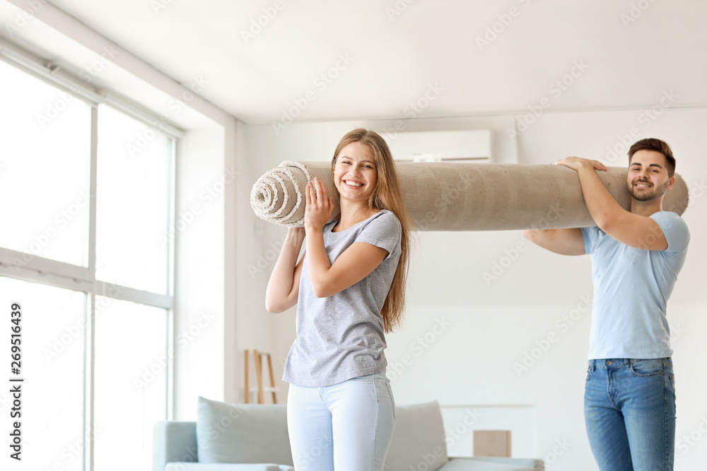 Young couple with carpet in new flat