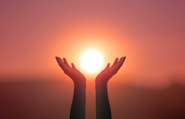 Wall Mural - free concept: raised hands catching sun on sunset sky