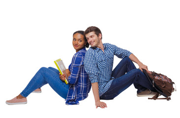 Side view of a couple of students who are sitting on the floor with their backs.