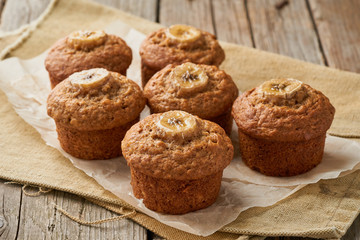 Banana muffin, side view. Cupcakes on old linen napkin, rustic wooden table, breakfast with cake