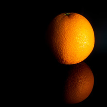 Orange Lies On The Table On A Black Background