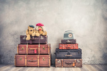 Vintage Outdated Trunks Luggage, Old Antique Leather Valises,  Pair Of Teddy Bear Toys And Classic Portable Radio Front Concrete Wall Background. Retro Style Filtered Photo