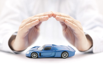 Poster - Car insurance concept with blue car toy covered by hands