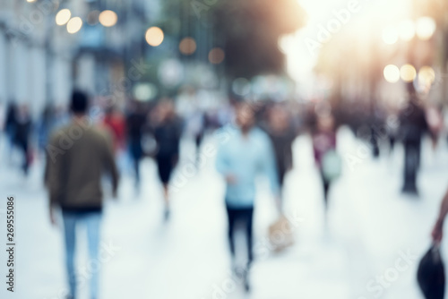 Plakat Unrecognizable people in bokeh walking along a evening street. Blurred image