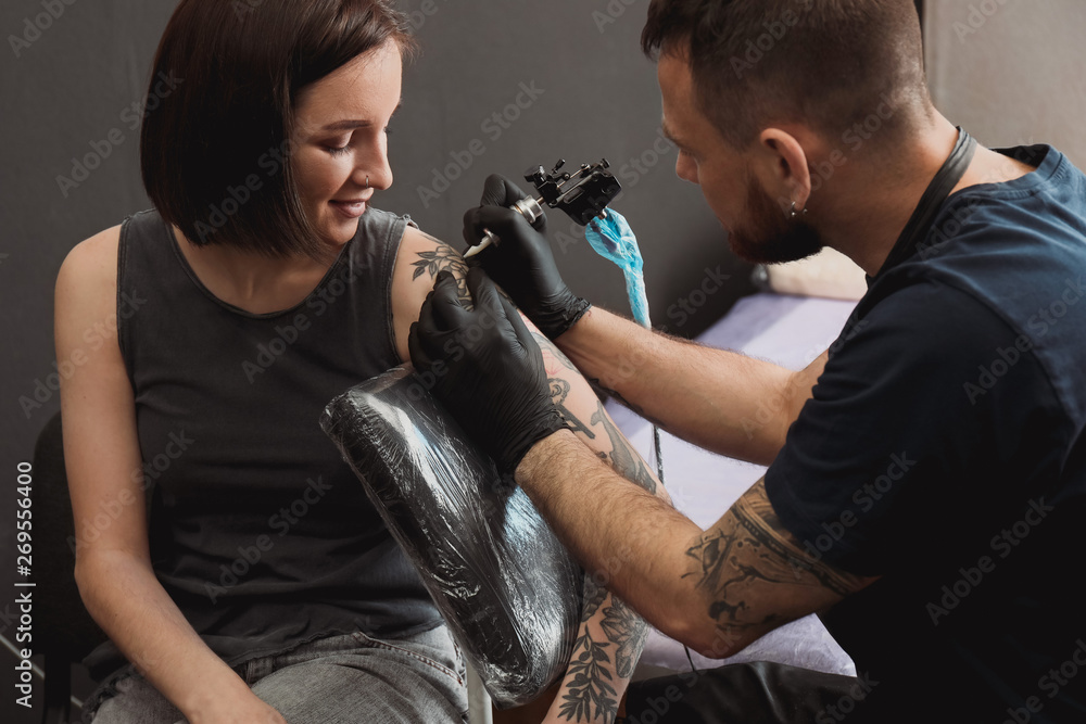 Professional artist making tattoo in salon