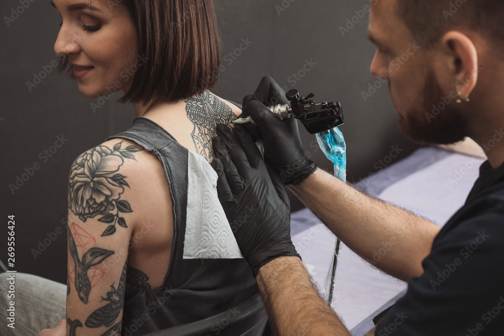 Professional artist making tattoo in salon