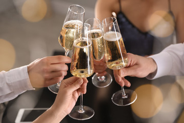 Canvas Print - Friends clinking glasses of champagne in restaurant, closeup