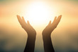 © paul - Free concept: Raised hands catching sun on sunset sky