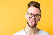 Portrait Of Positive, Cheerful Young Guy With Trendy Comb Over Haircut. Funny Emotional Man Sticking Tongue Out. Copy Space.