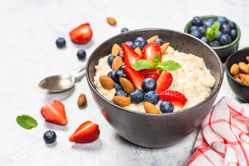 Wall Mural - Oatmeal porridge with fresh berries and nuts. 