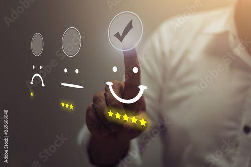 Fotografía Businessman pressing smiley face emoticon on virtual touch screen