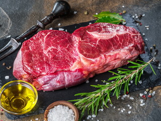 Wall Mural - Raw  Rib eye steak or beef steak on the graphite board with herbs and spices.