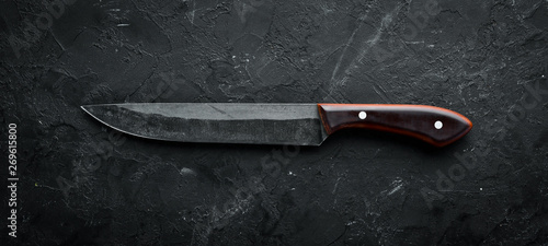 Fotomural Kitchen old knife on a black stone table