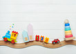 © lithiumphoto - Kids toys on toy wooden railway on white wooden background