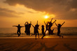 © Worawat - Silhouette photo of the team celebration on the beach at sunset