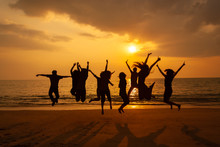 Silhouette Photo Of The Team Celebration On The Beach At Sunset