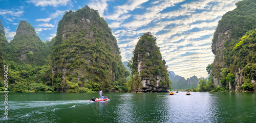 Valokuva  Ninh Binh, Vietnam - April 5th, 2019: People rowing boats for carrying tourists on Ngo Dong river of the Tam Coc National Park