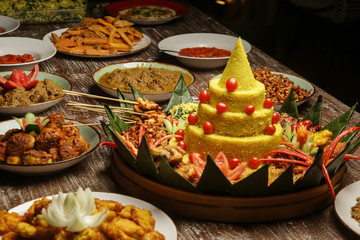 Nasi Tumpeng. Yellow rice in a cone shape. A festive Indonesian rice dish with side dishes.