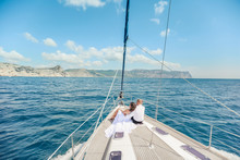 Young Couple Relaxing On A Yacht. Happy Wealthy Man And A Woman By Private Boat Have Sea Trip.
