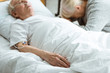 © LIGHTFIELD STUDIOS - selective focus of sad senior woman with husband in coma in clinic